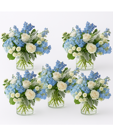 Elegant floral arrangement with blue hydrangea, white roses, delphinium, and button poms in a clear glass vase, designed by Walter Knoll Florist