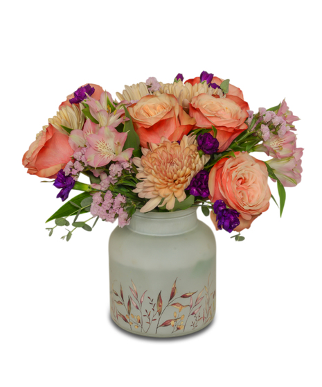 Frosted vase with botanical print filled with peach, pink and purple flowers.