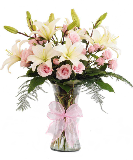 Irovy and pink flowers in a pink vase tied with a ribbon. 