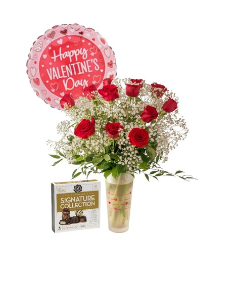 A romantic Valentine’s arrangement of fresh red roses and white baby’s breath arranged in a clear glass vase with heart accents and lush green foliage.