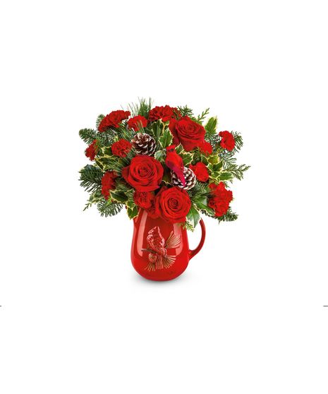 Festive red floral arrangement with roses, carnations, pinecones, and evergreens in a red cardinal pitcher, perfect for Christmas decorating or gifting.