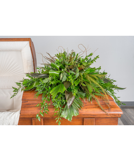A serene half casket spray composed entirely of lush, tropical greenery.