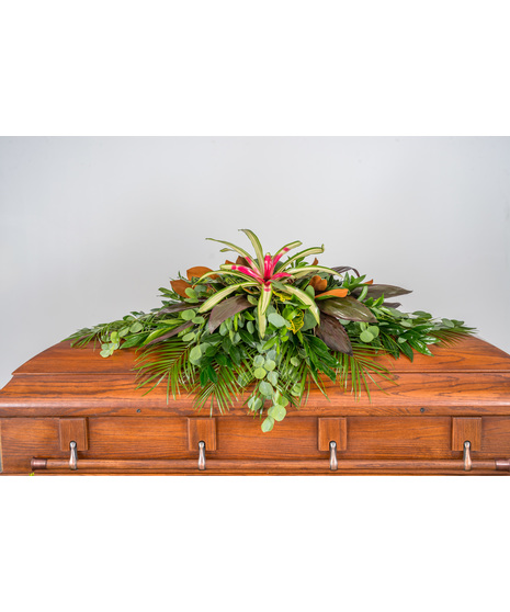 A serene half casket spray composed entirely of lush, tropical greenery.