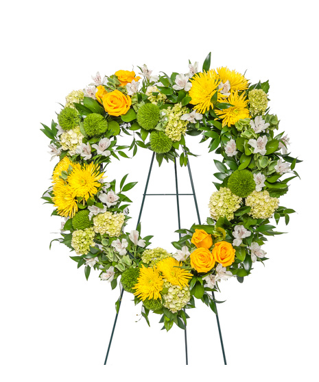Standing sympathy floral easel in yellow, white, and green featuring roses, mums, hydrangea, and greenery, available as a starburst display, heart tribute, or wreath.