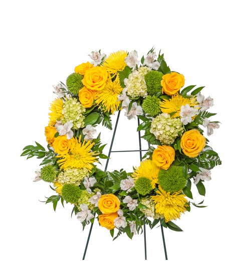 Standing sympathy floral easel in yellow, white, and green featuring roses, mums, hydrangea, and greenery, available as a starburst display, heart tribute, or wreath.